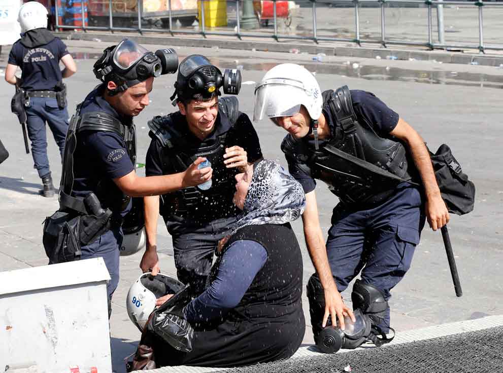 Policías-ayudan-a-mujer-afectada-por-el-gas-lacrimógeno.-Ankara,-Turquía,-2013.